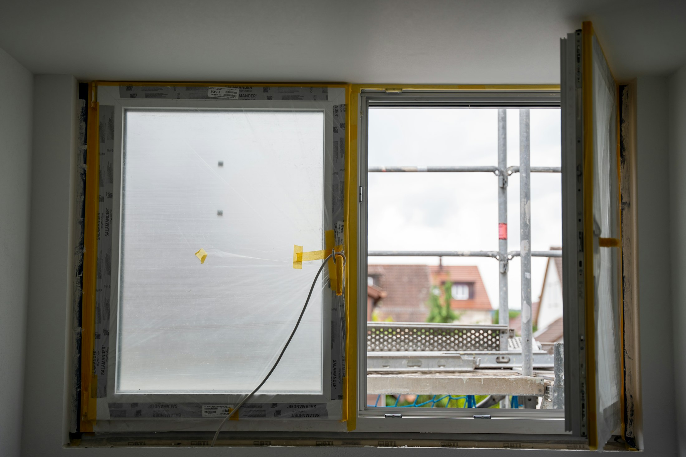 Offenes Fenster auf einer Baustelle mit sichtbarer Montage- und Ausbausituation